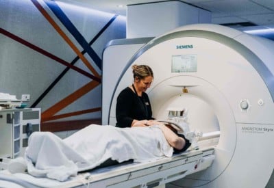 Lady talking to patient about to have an 18F-DOPA imaging scan