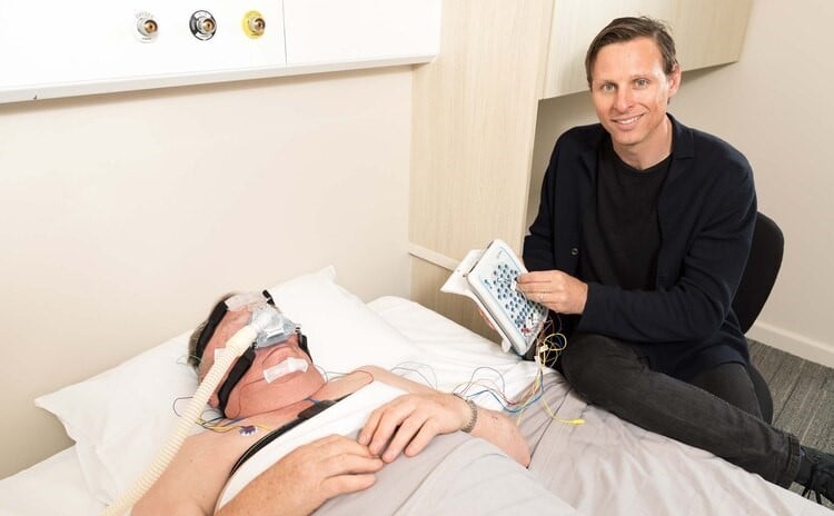 Man lying a bed with CPAP sleep mask
