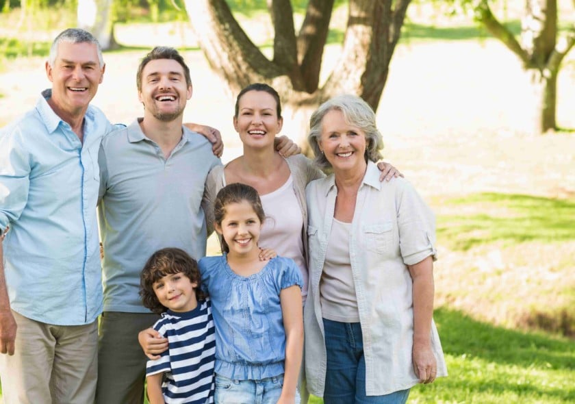 Three generations of family smiling at camera