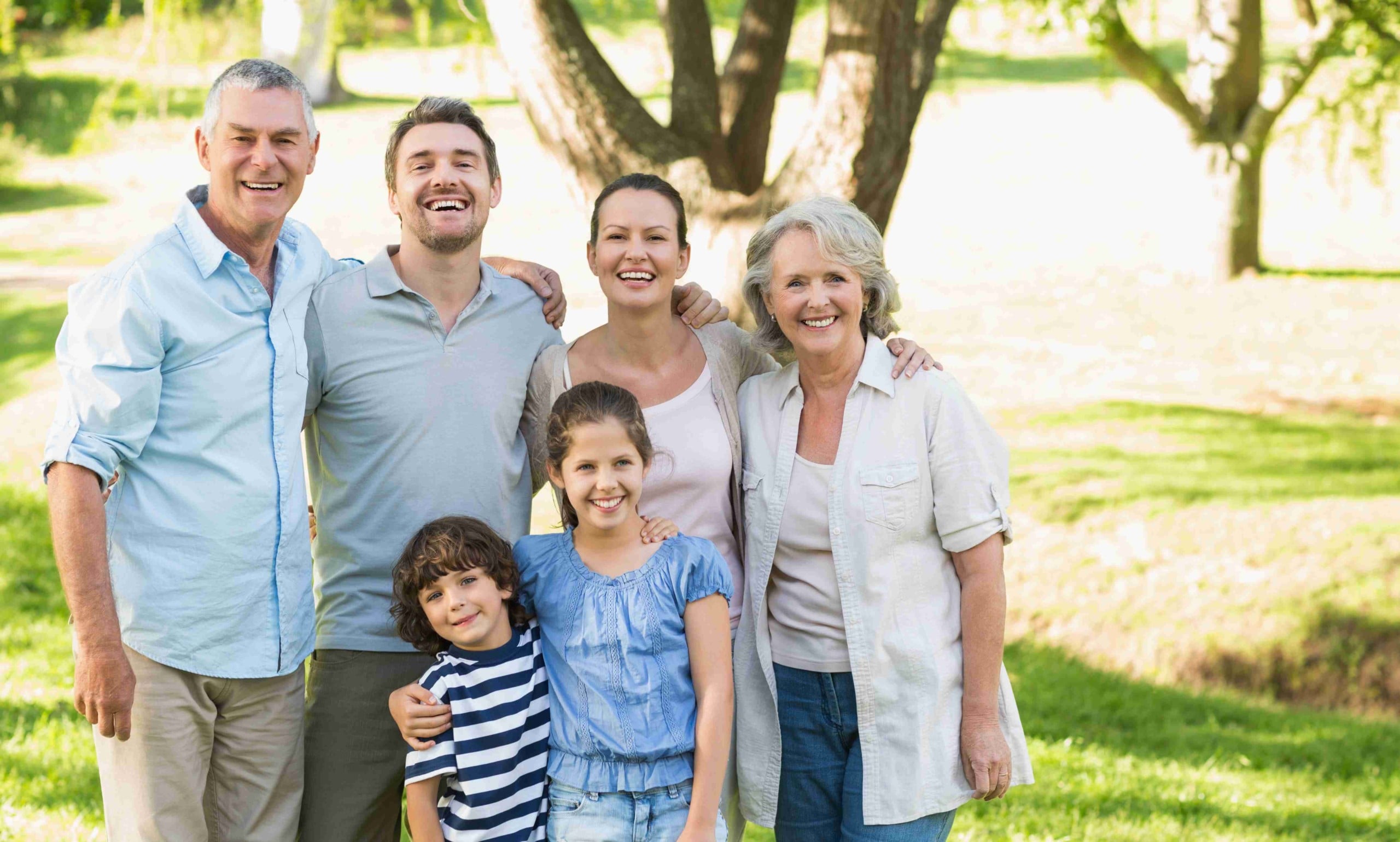 Three generations of family smiling at camera