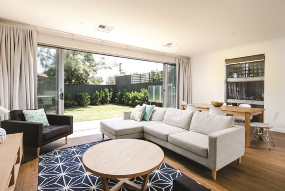 Lounge room with large family couch opening up to green courtyard.