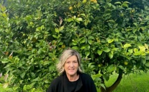 bowel cancer patient Jackie outside in front of large green tree