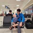 Jay in airport with young son on lap