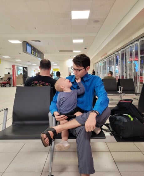 Jay in airport with young son on lap
