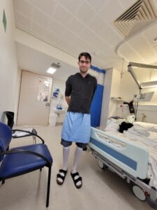 Jay standing in hospital room wearing compression socks