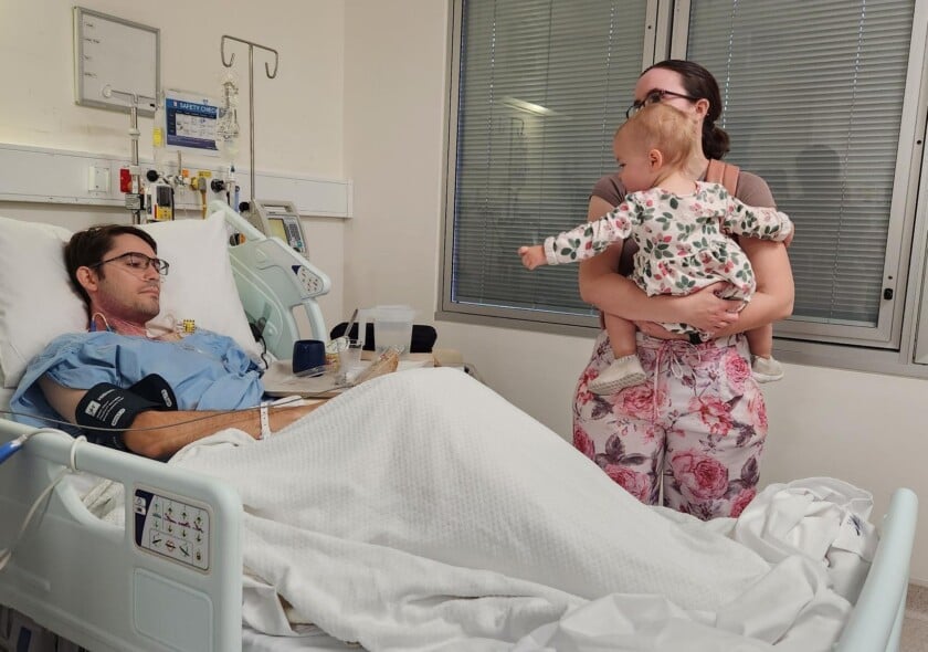 Jay in hospital with partner and young child visiting