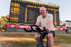 Mark Mickan on an exercise back in front of the Adelaide Oval scoreboard.